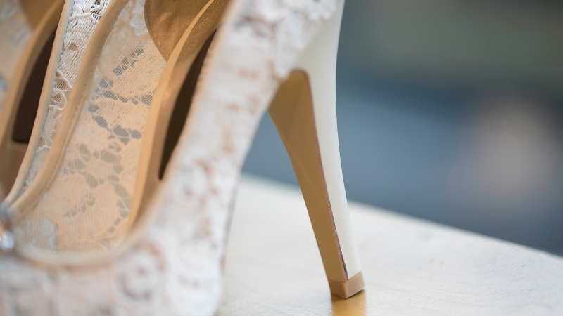 Čipkane svadbene štikle stoje na stolu